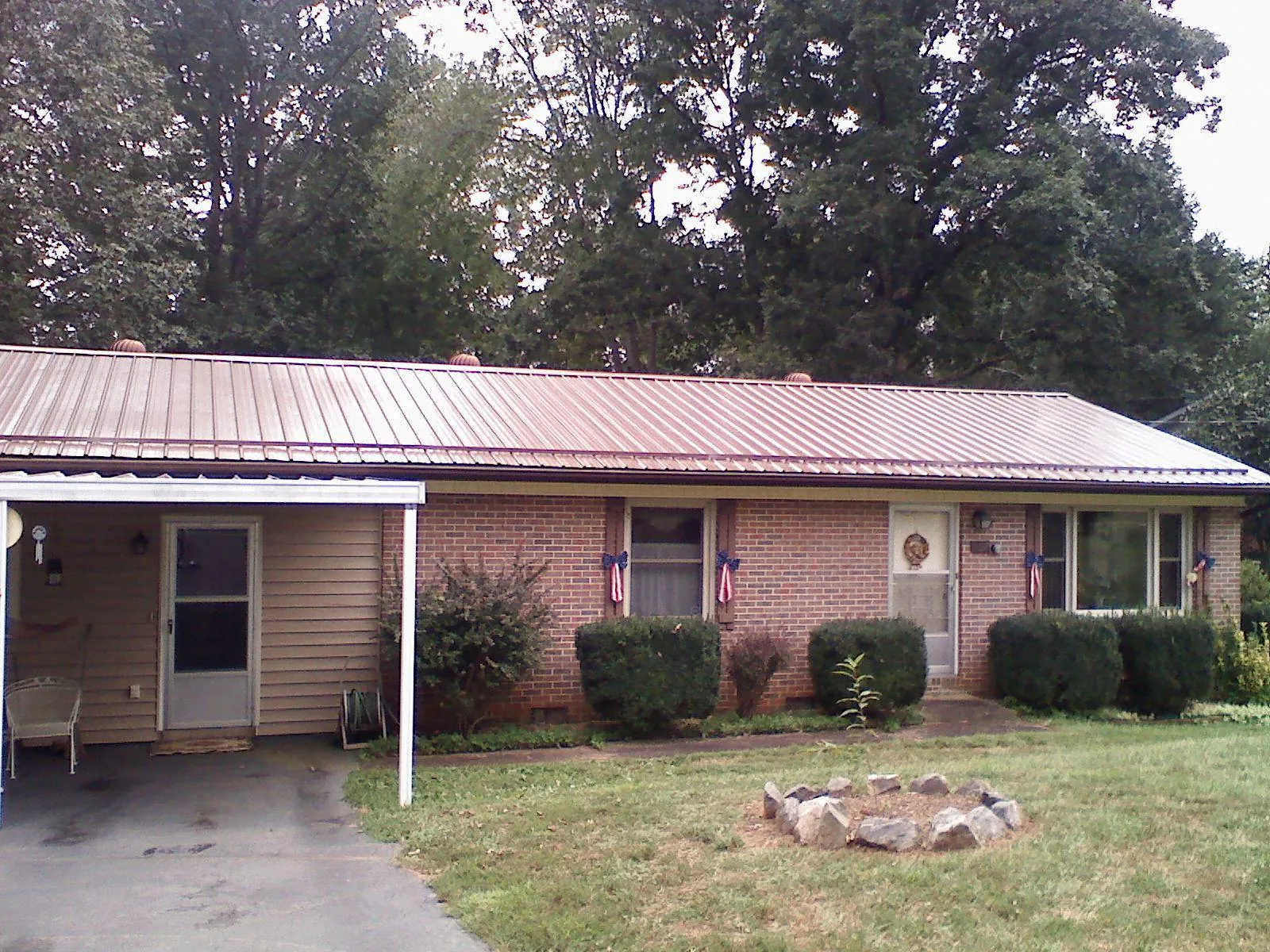 Bronze metal roof and carport on a brick ranch home — Roof Repair work by our crew in London